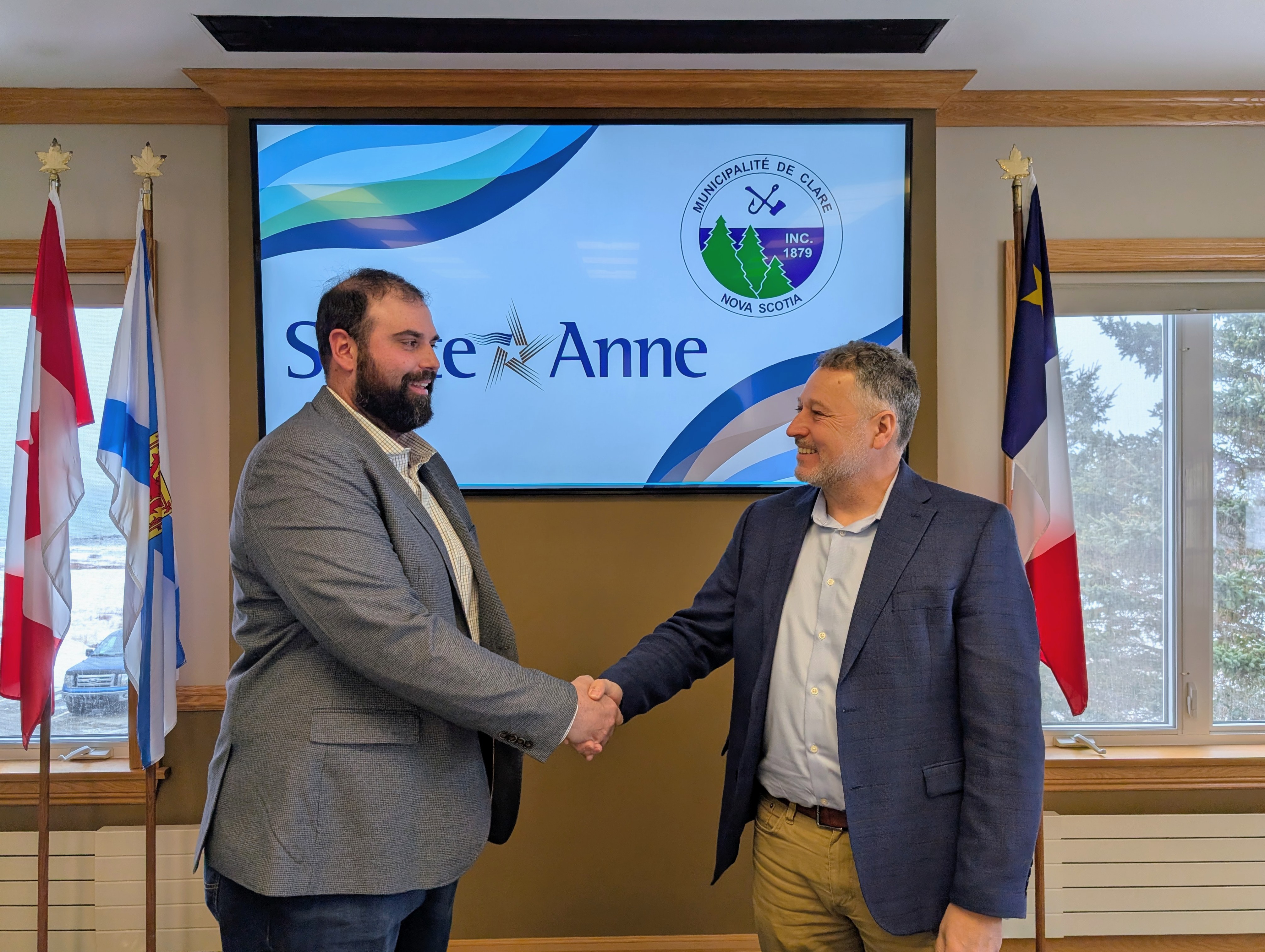 Une photographie du directeur Yvon LeBlanc et du président et vice-chancelier Kenneth Deveau se serrant la main.