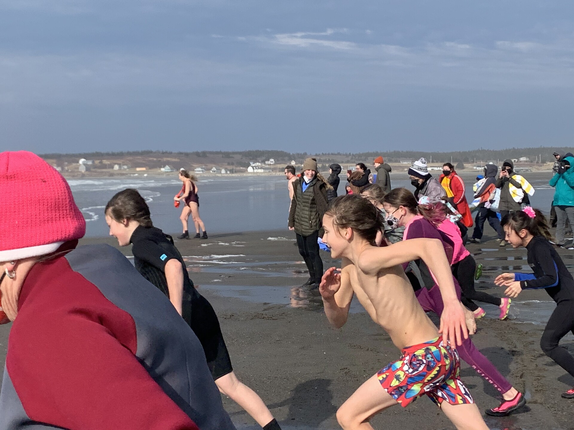 People running into the ocean